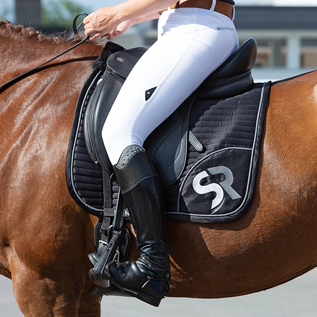 sr embroidery of breathable dressage saddle pad silver and black exclusive line with fur on withers under saddle on a horse
