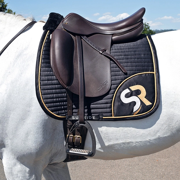 breathable dressage saddle pad gold and black exclusive line with fur on withers under saddle on a horse