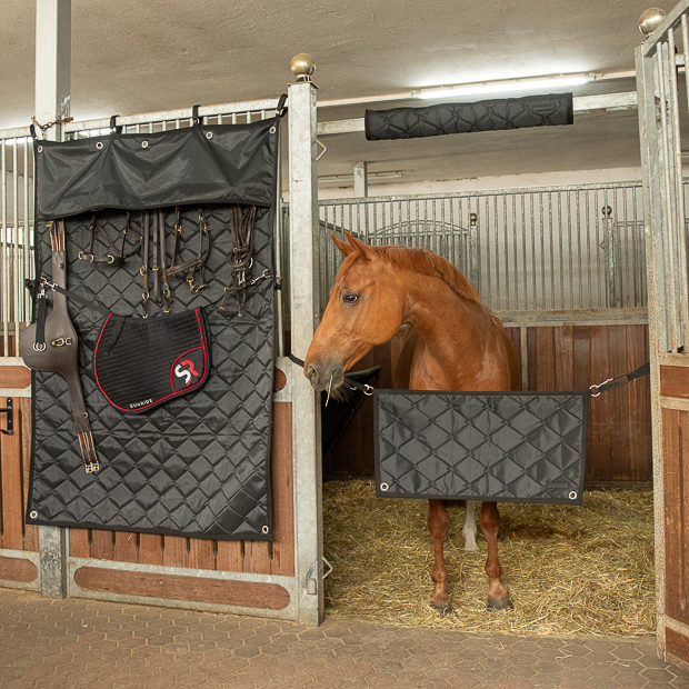 schwarzer boxenvorhang fuer den stall mit eingearbeiteten haeken und oesen und strippen zur aufbewahrung von sunride an der box im stall befestigt