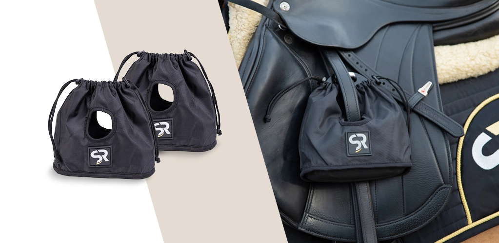 Steigbügelschoner Zwei schwarze Steigbügelschoner mit SR Logo liegen nebeneinander rechts daneben ein Sattel mit aufgezogenen Steigbügelschonern
