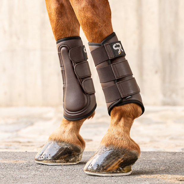 brown dressage leather boots from leather and neoprene inside with elastic velcro closures on the horse leg