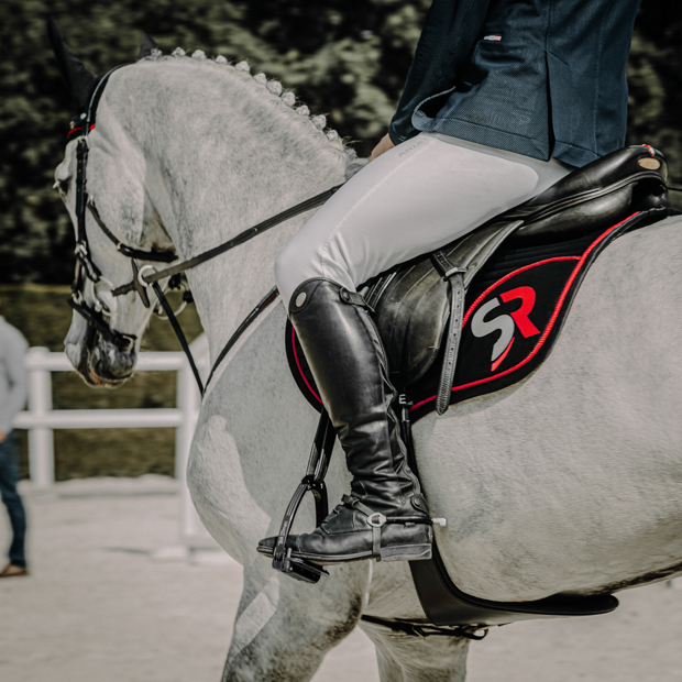 springschabracke exclusive line schwarz rot am pferd mit reiter schwarz rote springschabracke aus der exclusive line von sunride am pferd mit reiter