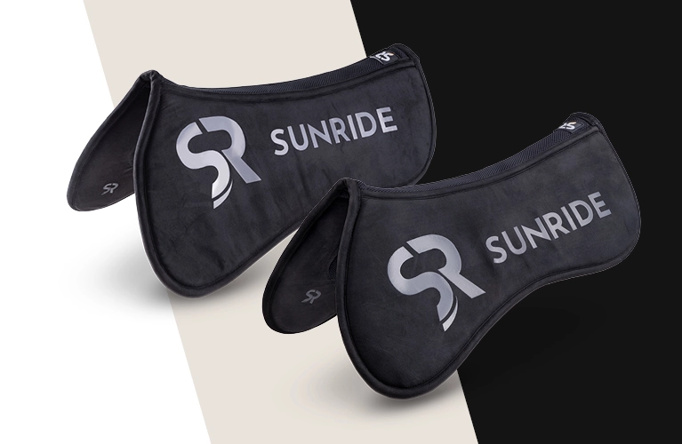 Sattelpad Cloud One Zwei schwarze Sattelpads mit dem SUNRIDE Logo liegen nebeneinander